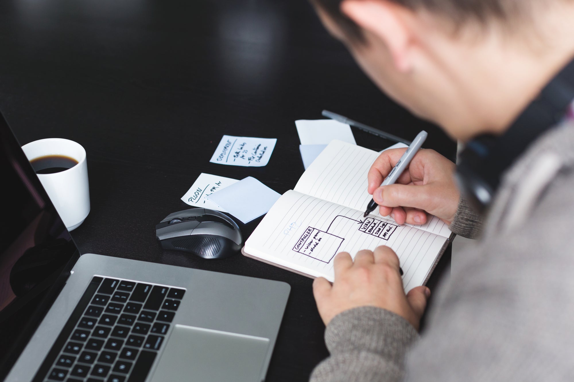 man writing in notebook